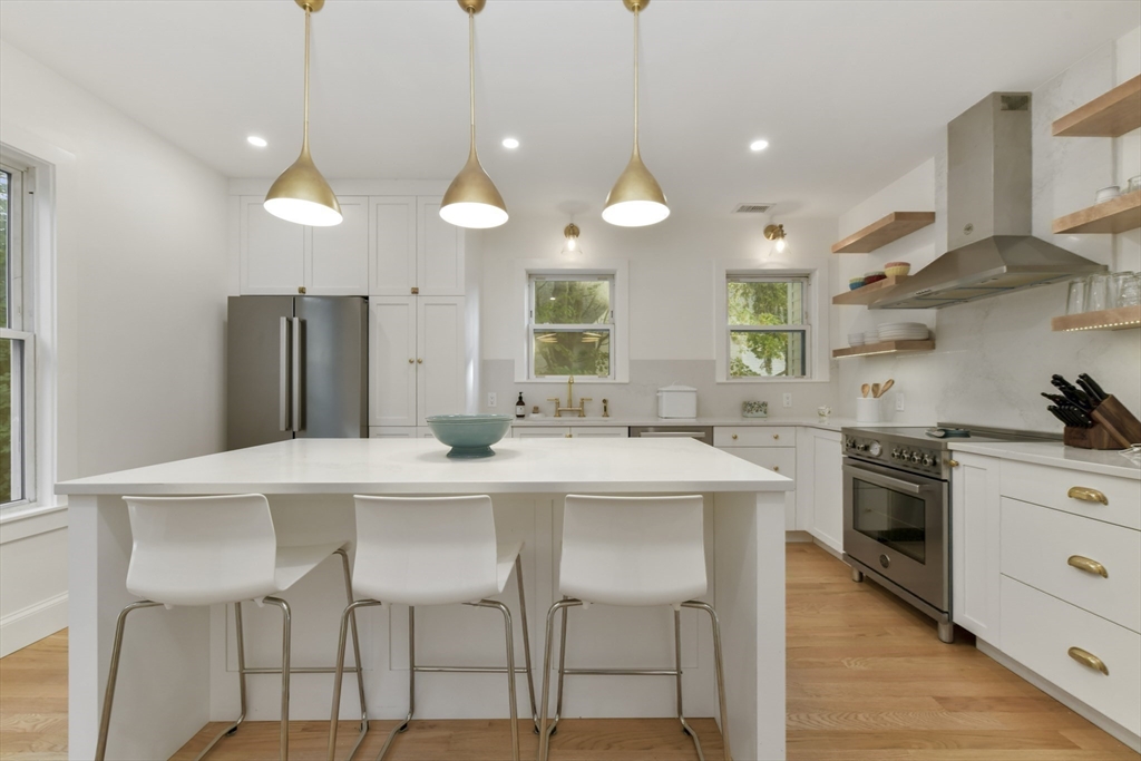 26 Bartlett Avenue Arlington, MA 02476 - Photo 3 of 27 a kitchen with stainless steel appliances a table chairs sink and stove top oven