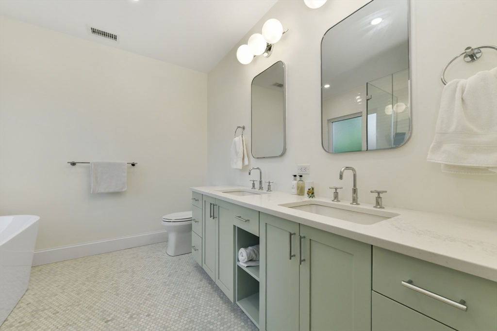 26 Bartlett Avenue Arlington, MA 02476 - Photo 10 of 27 a bathroom with a granite countertop sink a toilet and a mirror