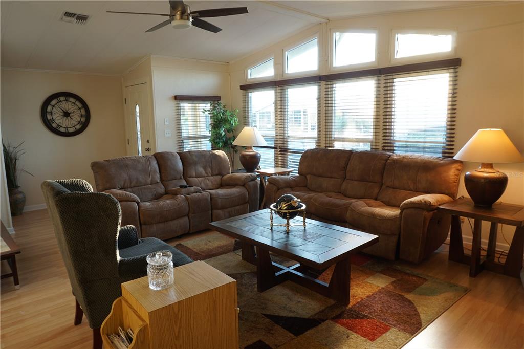 145 Rarotonga Road North Port, FL 34287 - Photo 11 of 64 a living room with furniture a clock on wall and a large window