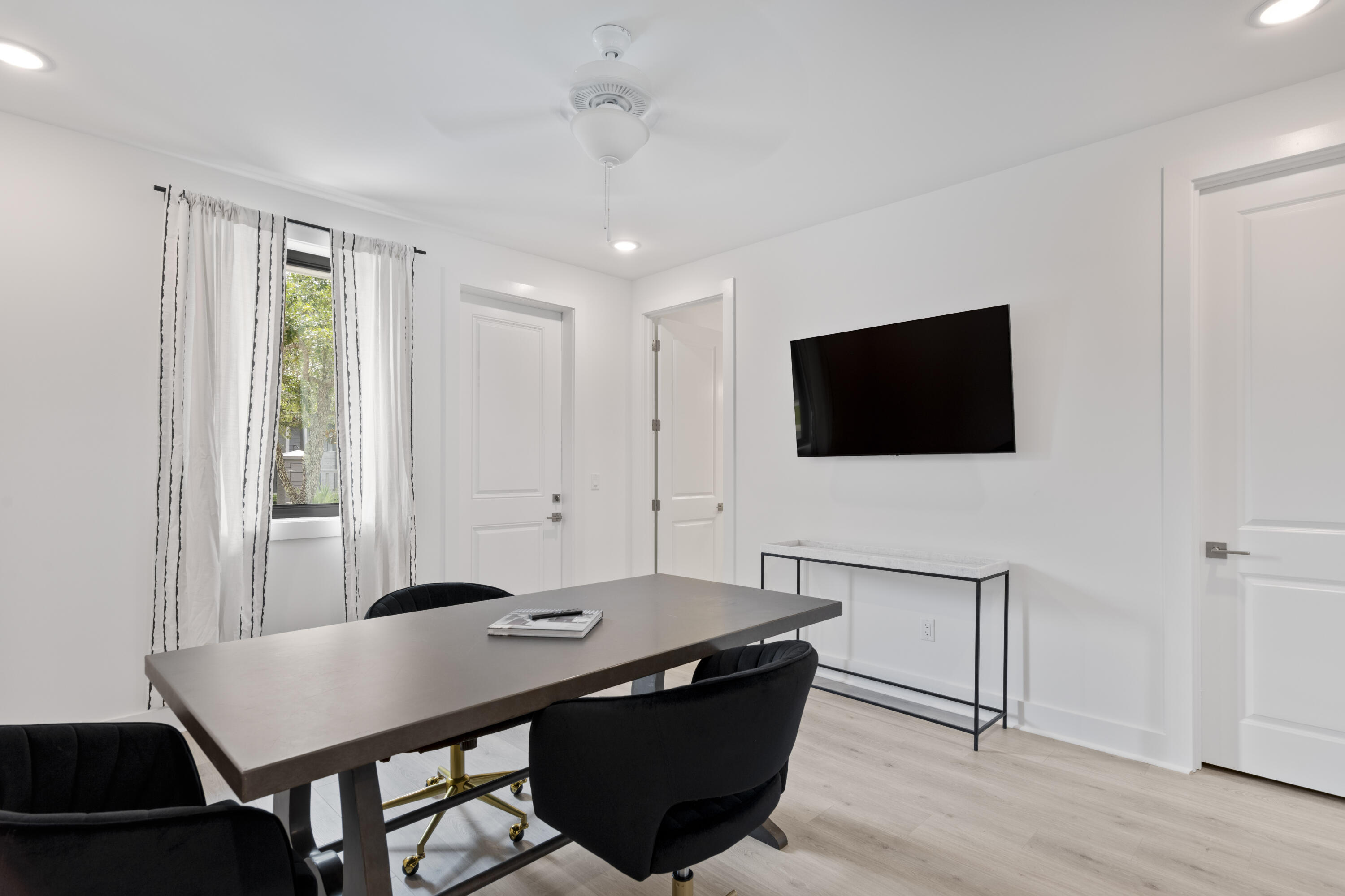 50 Blue Eden Loop, Unit LOT 39 Santa Rosa Beach, FL 32459 - Photo 27 of 29 a living room with a flat screen tv a dining table and chairs with wooden floor