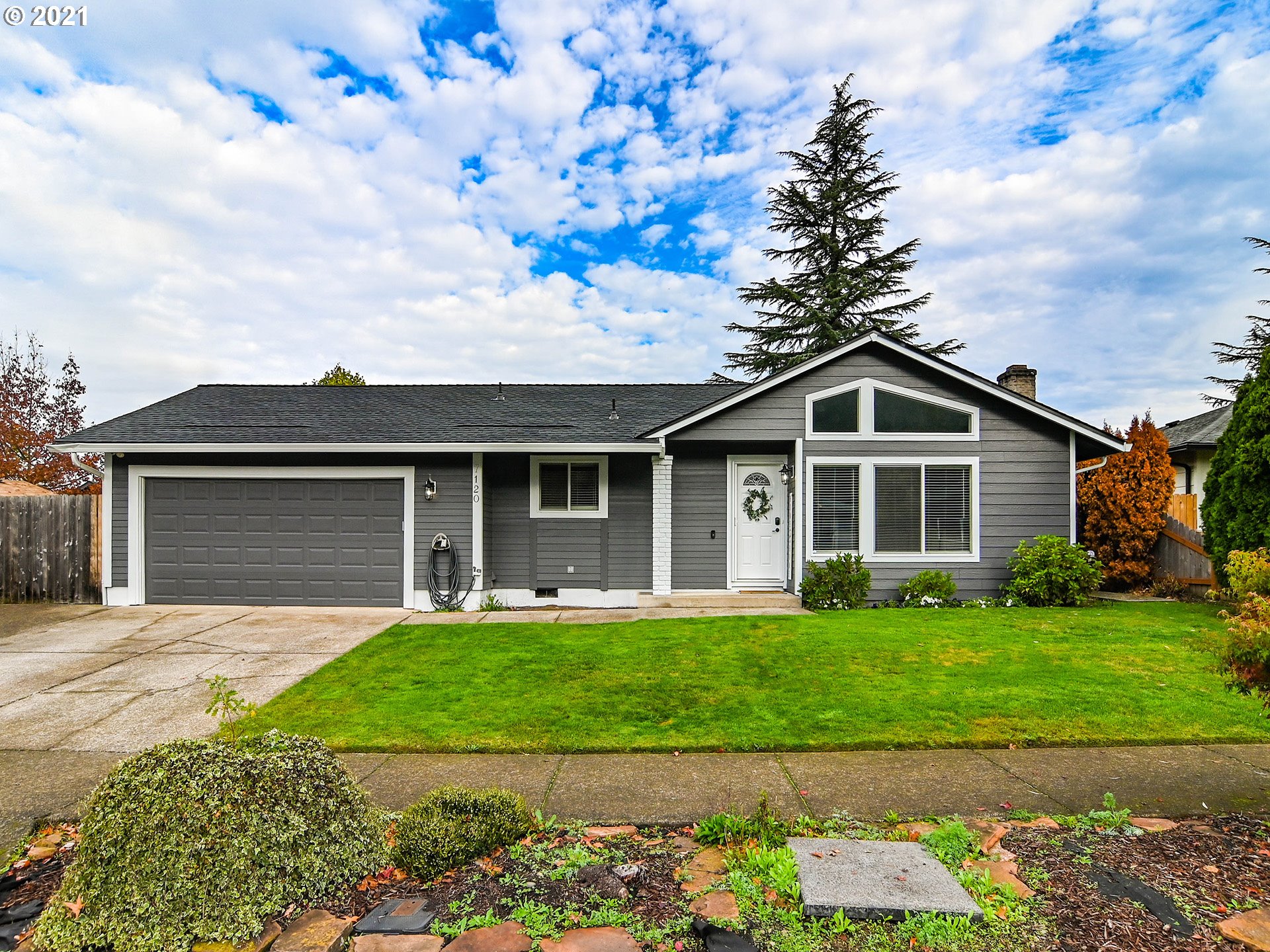 7120 B Street Springfield, OR 97478 - Photo 2 of 32 a front view of a house with a yard and garage