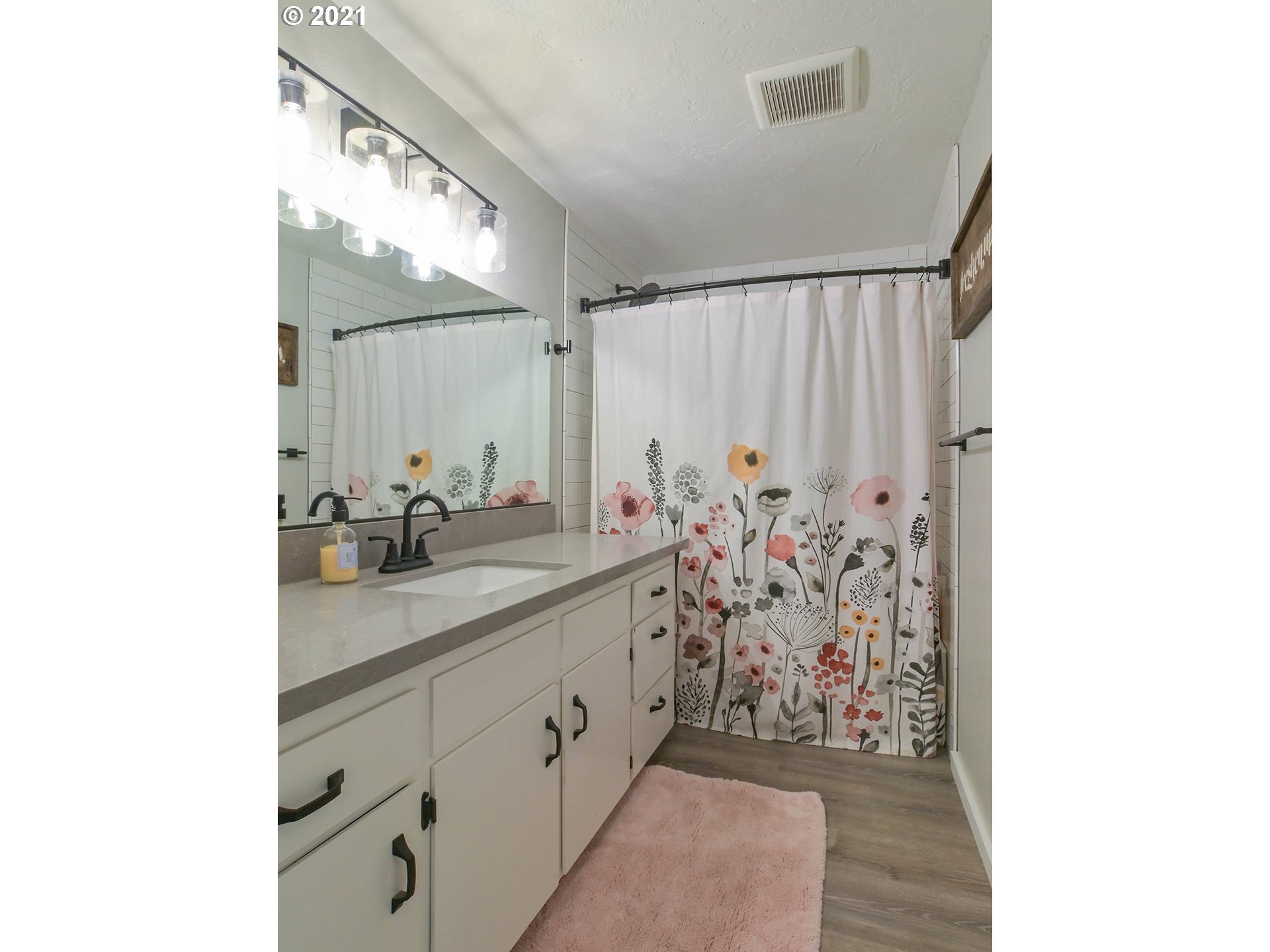 7120 B Street Springfield, OR 97478 - Photo 17 of 32 a bathroom with a granite countertop sink a mirror and shower