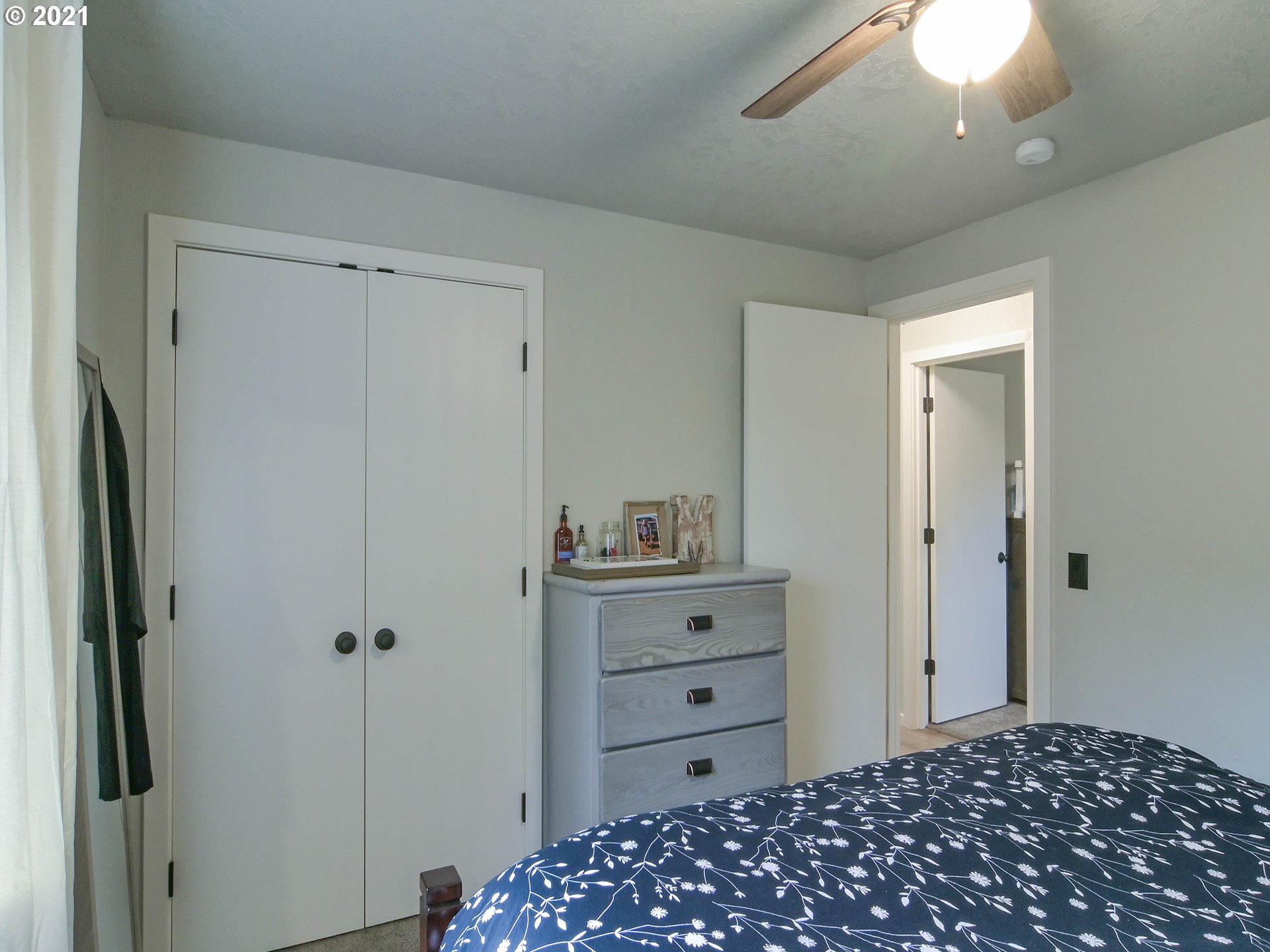 7120 B Street Springfield, OR 97478 - Photo 21 of 32 a bedroom with a dresser and a chandelier