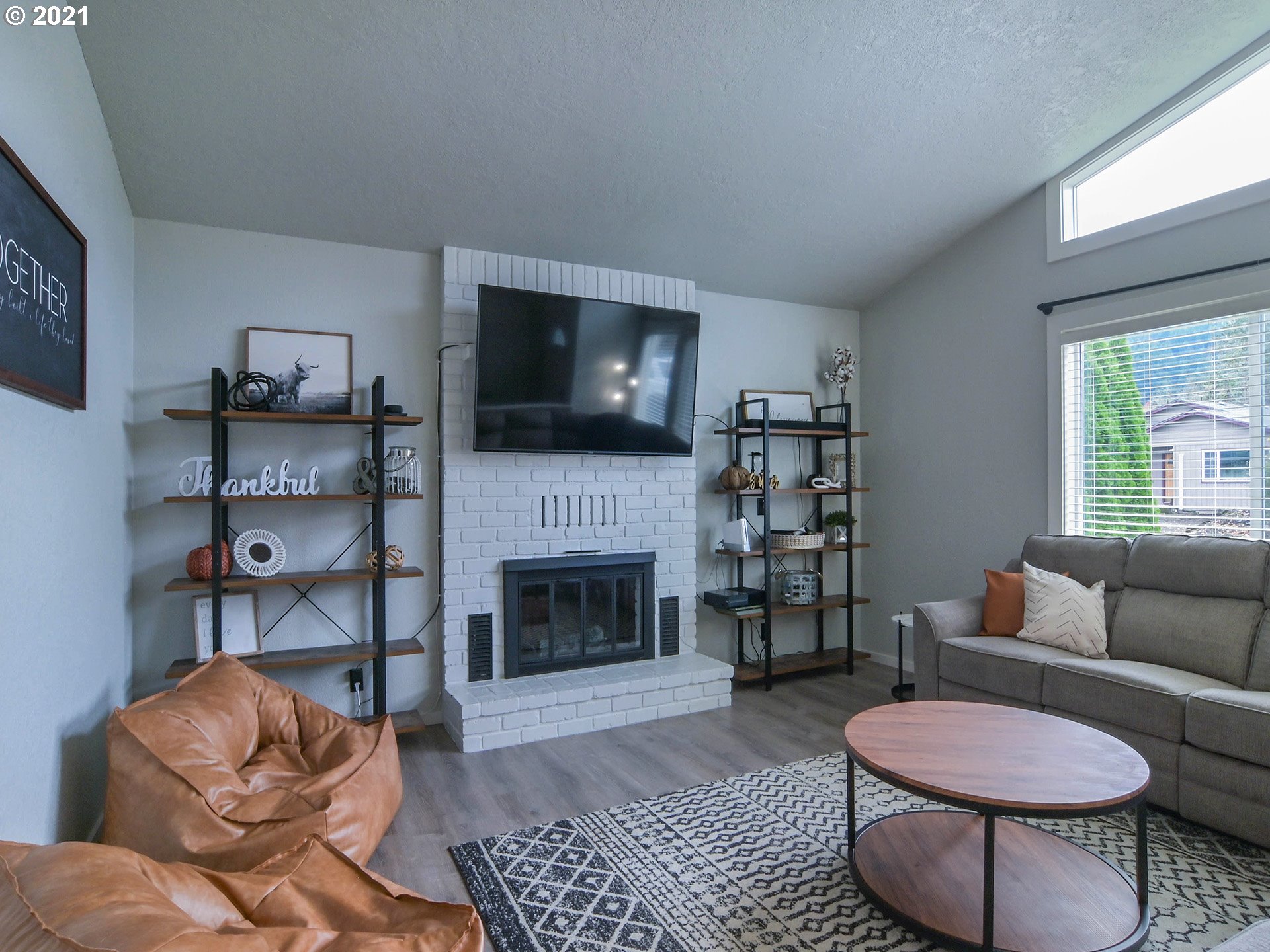 7120 B Street Springfield, OR 97478 - Photo 5 of 32 a living room with furniture a flat screen tv and a fireplace