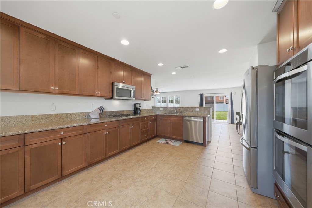 3439 Joshua Tree Court Perris, CA 92570 - Photo 26 of 49 a kitchen with stainless steel appliances granite countertop a refrigerator sink and cabinets