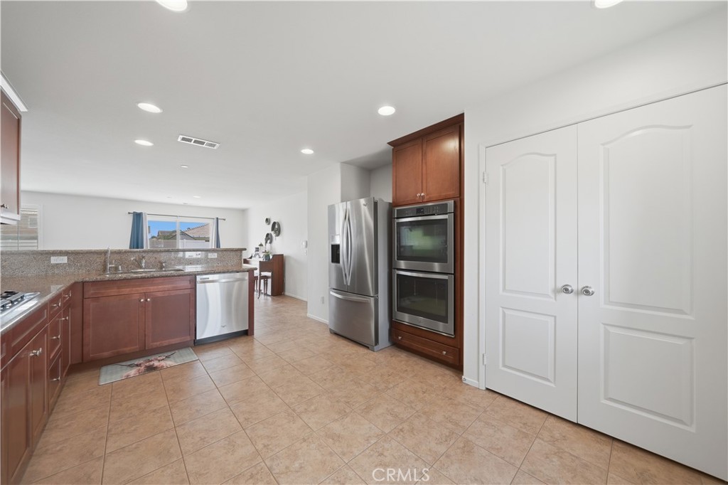 3439 Joshua Tree Court Perris, CA 92570 - Photo 27 of 49 a large kitchen with a large window and stainless steel appliances