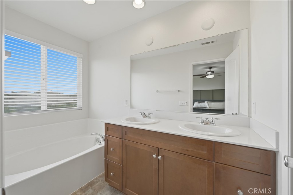 3439 Joshua Tree Court Perris, CA 92570 - Photo 36 of 49 a bathroom with a sink double vanity granite tub shower and a mirror