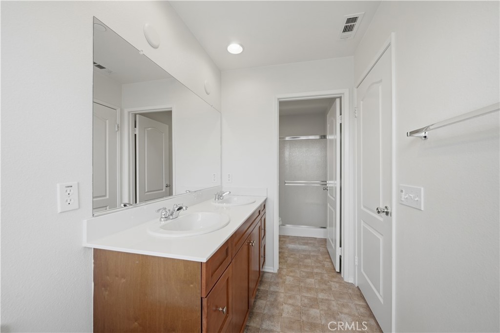 3439 Joshua Tree Court Perris, CA 92570 - Photo 37 of 49 a bathroom with a sink a mirror and a vanity