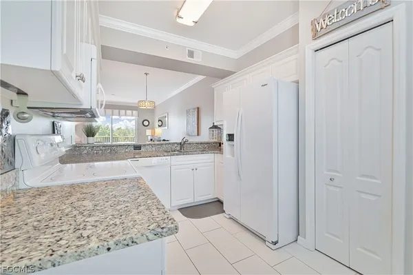 a kitchen with stainless steel appliances granite countertop a refrigerator and a sink