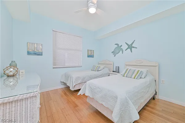 a bedroom with two beds and painting on the wall