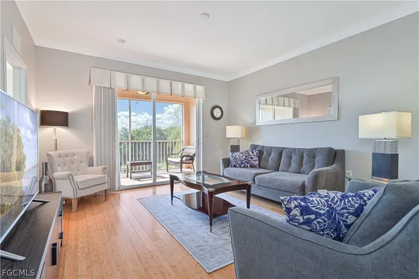 a living room with furniture and a large window with wooden floor