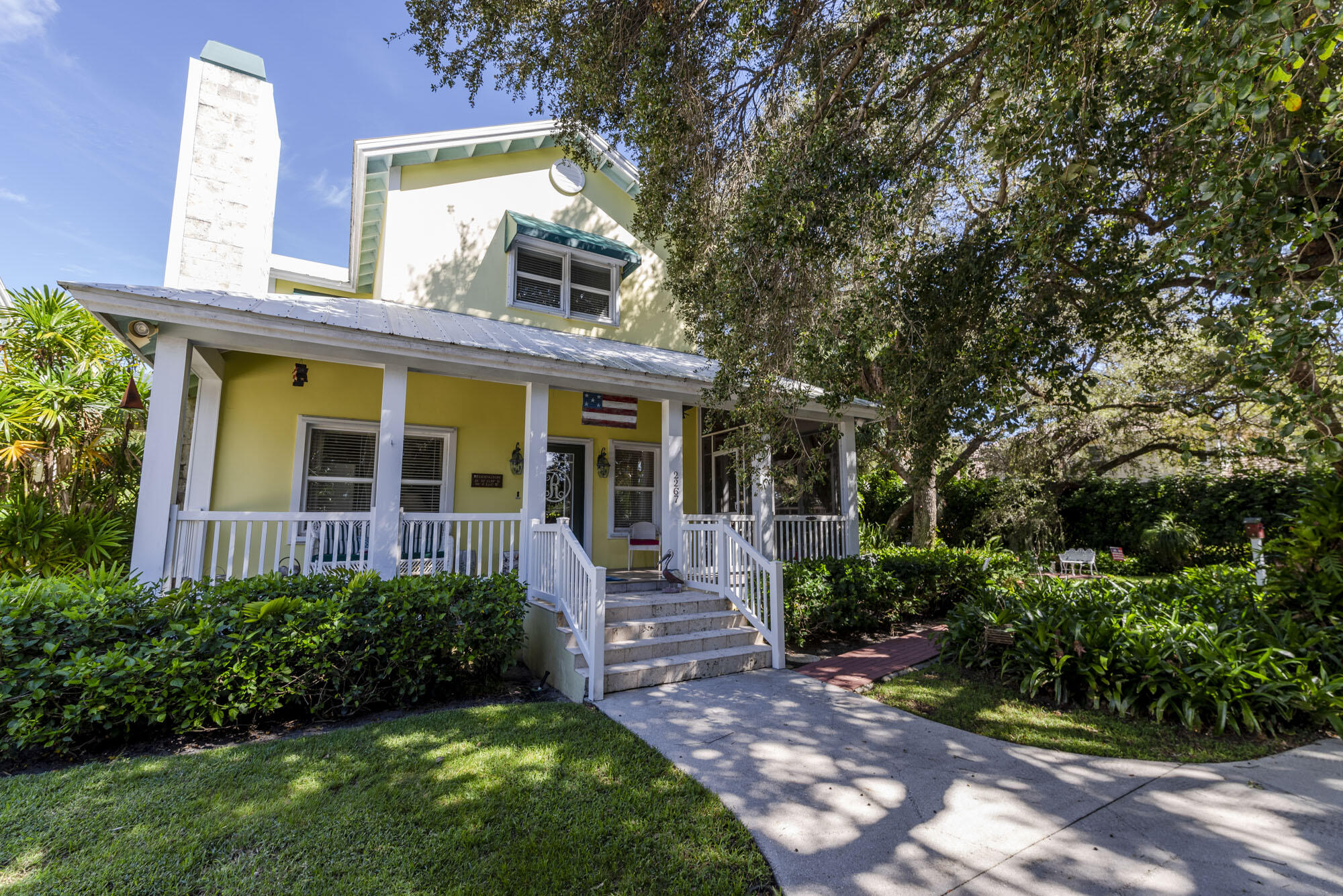 2267 Windsor Road Palm Beach Gardens, FL 33410 - Photo 4 of 45 a view of a house with brick walls and a large tree