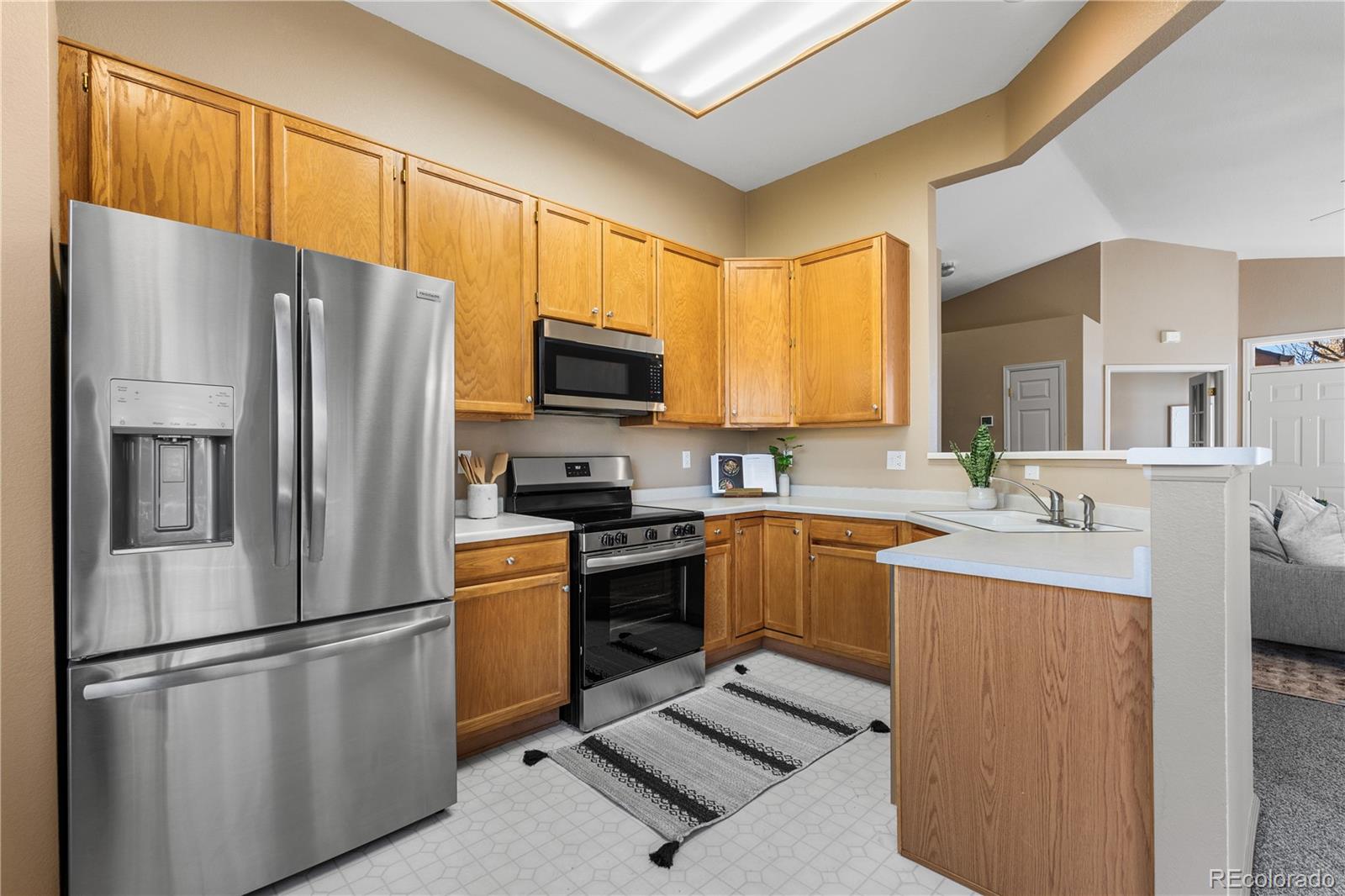 12799 East Wyoming Circle Aurora, CO 80012 - Photo 18 of 44 a kitchen with stainless steel appliances granite countertop a refrigerator stove microwave and sink