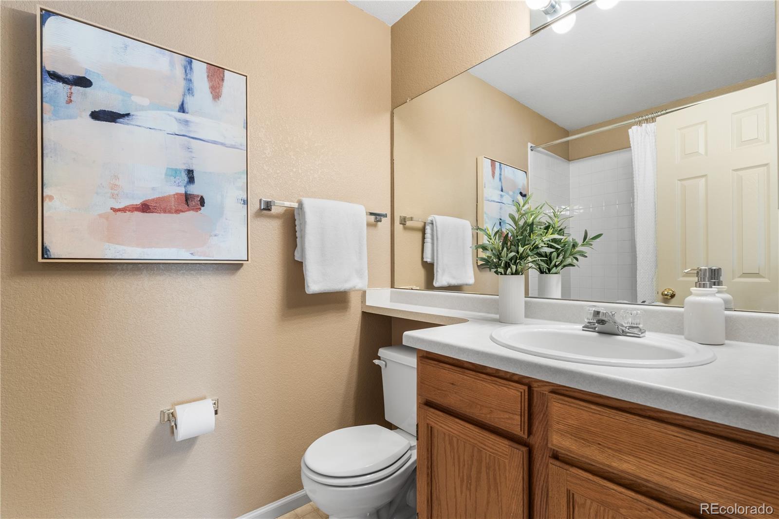 12799 East Wyoming Circle Aurora, CO 80012 - Photo 30 of 44 a bathroom with a sink a toilet and shower curtain