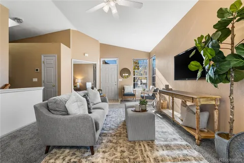 a living room with furniture a chandelier and a potted plant