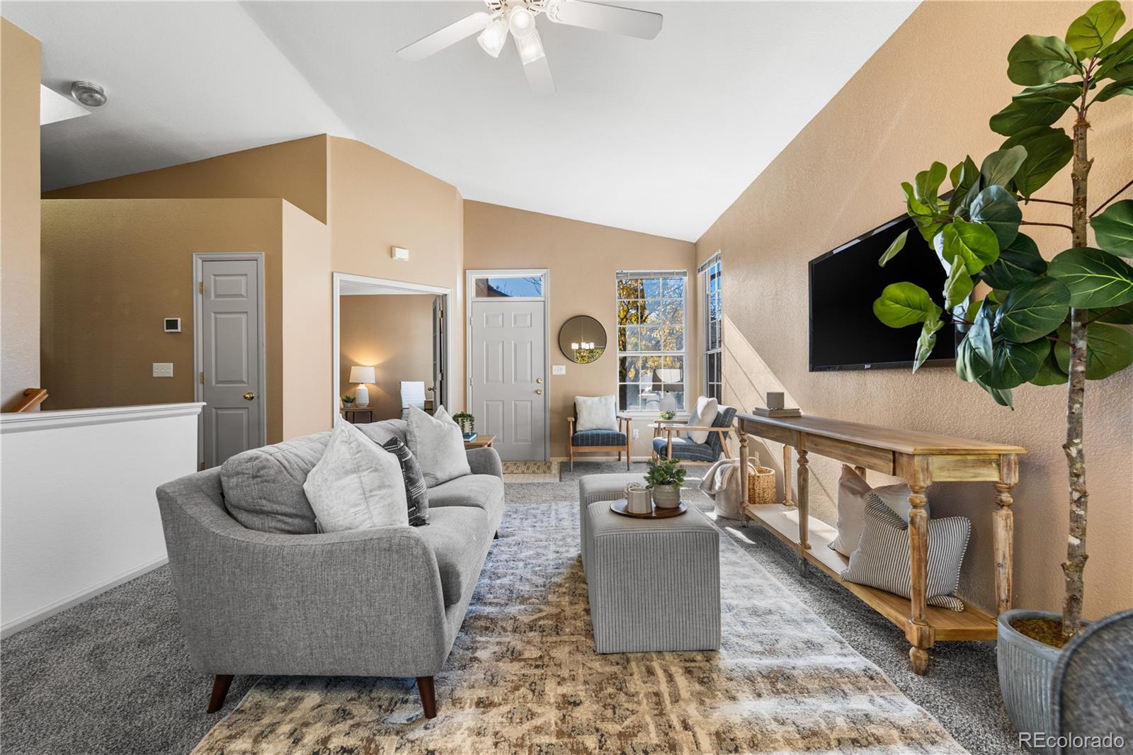 12799 East Wyoming Circle Aurora, CO 80012 - Photo 5 of 44 a living room with furniture a chandelier and a potted plant