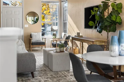 a living room with furniture a potted plant and a wooden floor