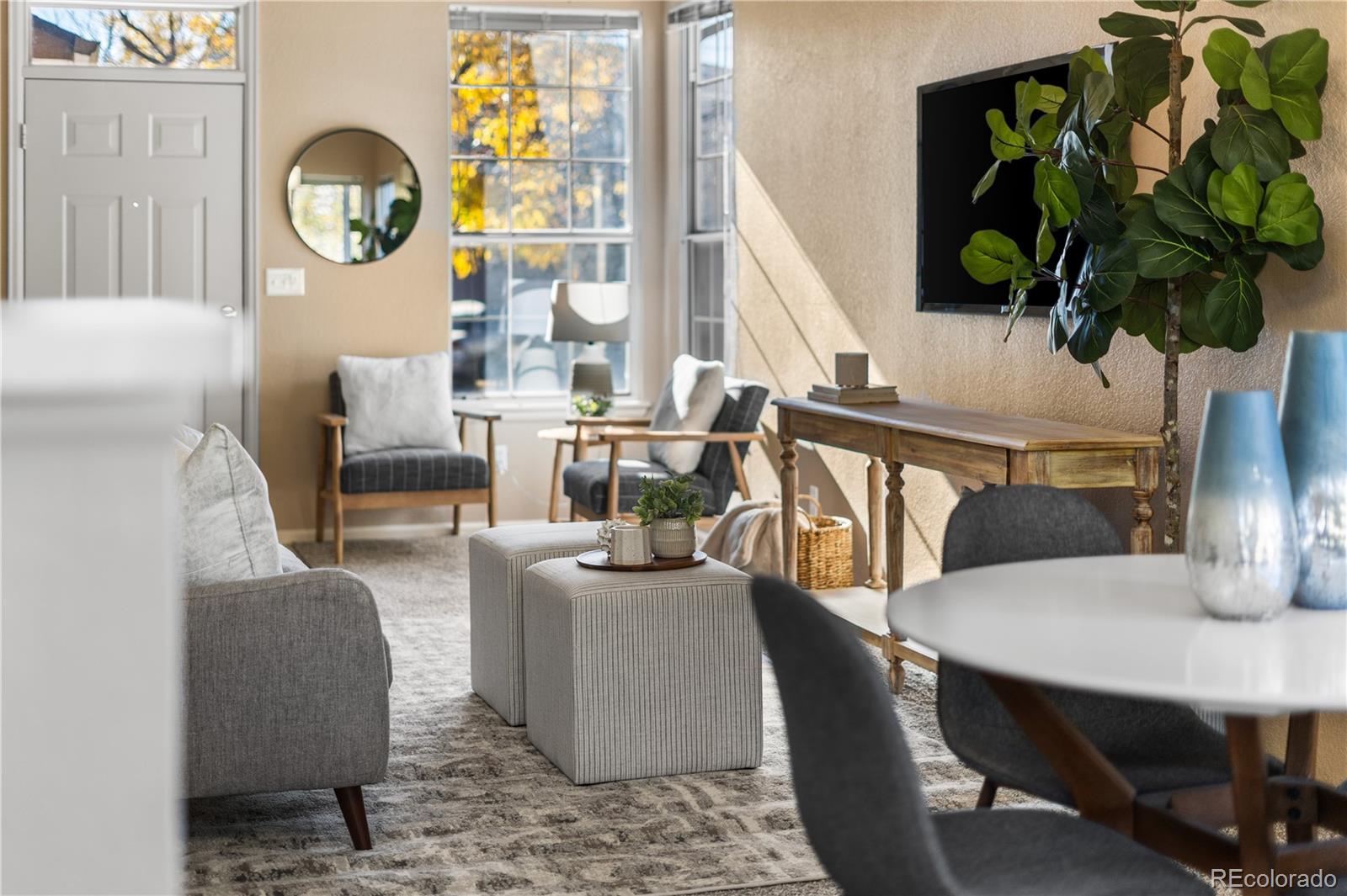 12799 East Wyoming Circle Aurora, CO 80012 - Photo 8 of 44 a living room with furniture a potted plant and a wooden floor