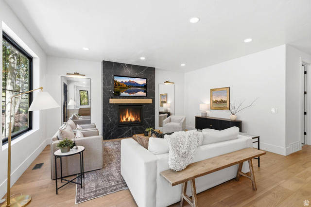 3027 Homestead Road Park City, UT 84098 - Photo 11 of 62 Spacious room featuring light wood-finish flooring, recessed lighting, and a modern fireplace with a dark stone surround and wood mantel
