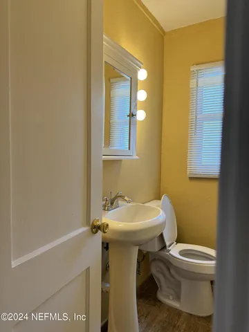 a bathroom with a sink toilet and mirror