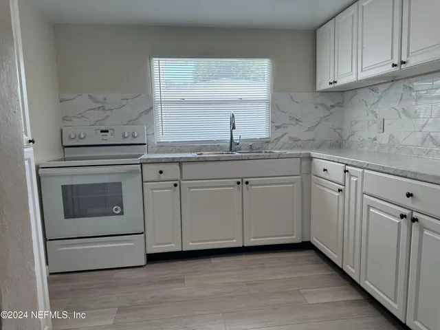 a kitchen with white cabinets and white appliances