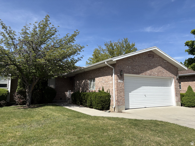 486 West 120 North Orem, UT 84057 - Photo 1 of 30 Brick exterior featuring a white garage door, concrete driveway, and front lawn