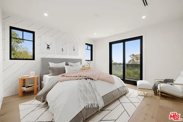 a bedroom with a bed and a potted plant