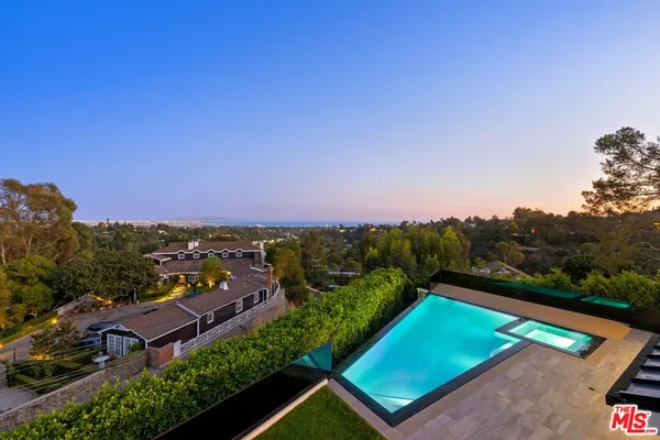 an aerial view of a residential houses with a yard and lake view