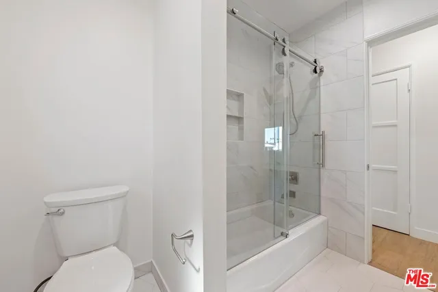 a bathroom with a shower a toilet and a bathtub