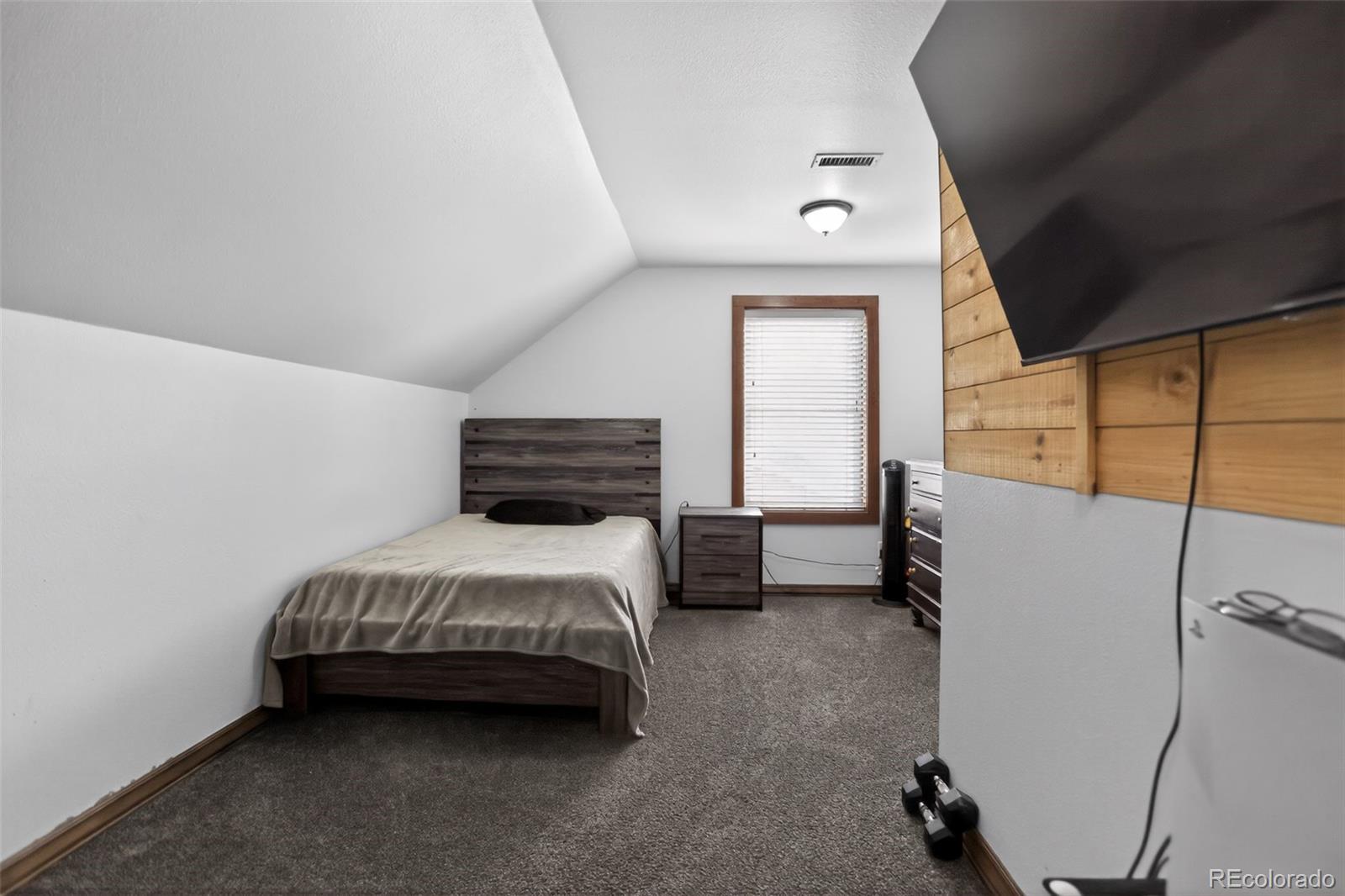 10 Salmon Loop Gypsum, CO 81637 - Photo 11 of 15 a bedroom with a bed a dresser and a window