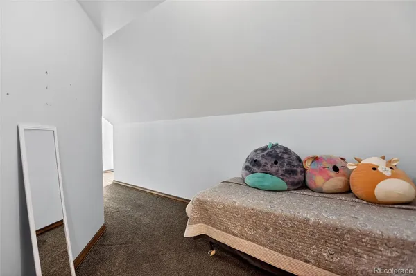 a bedroom with a bed and teddy bear on dresser