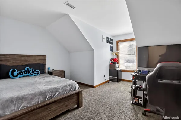 a bedroom with a bed a desk and a couch
