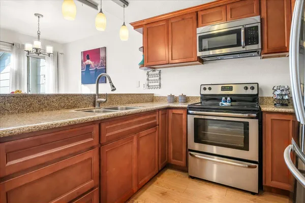 a kitchen with stainless steel appliances granite countertop a stove microwave and sink