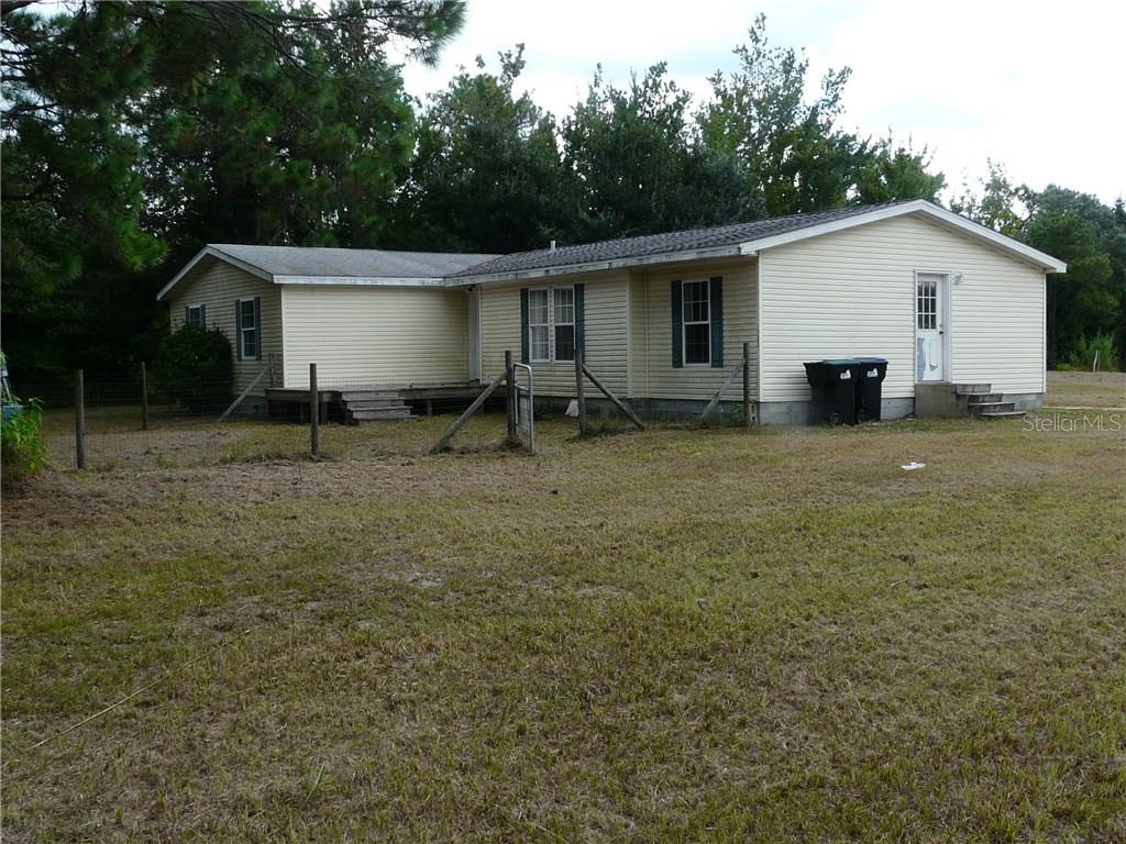 a backyard of a house with table and chairs