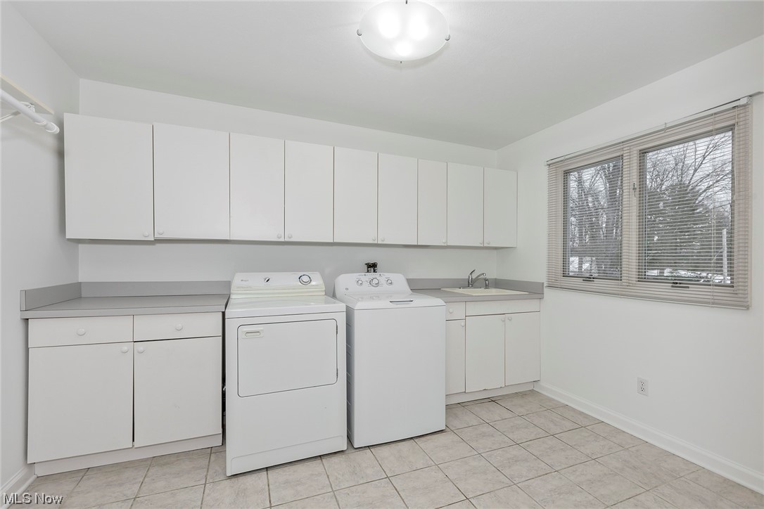 3850 Ellendale Road Moreland Hills, OH 44022 - Photo 21 of 39 Laundry room with cabinets, washing machine and clothes dryer, sink, and ceramic tile floors