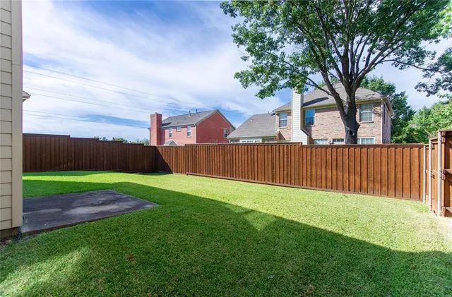 a view of a backyard with wooden fence