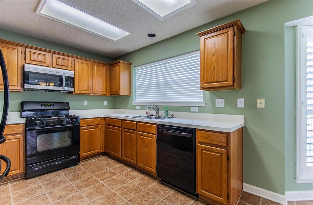 4117 Oxlea Drive Plano, TX 75024 - Photo 5 of 17 a kitchen with stainless steel appliances granite countertop a stove sink and cabinets