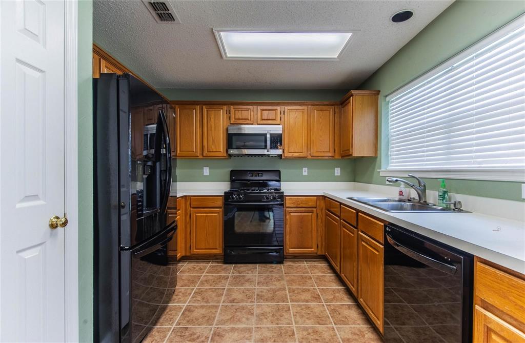 4117 Oxlea Drive Plano, TX 75024 - Photo 7 of 17 a kitchen with granite countertop stainless steel appliances a stove sink and cabinets