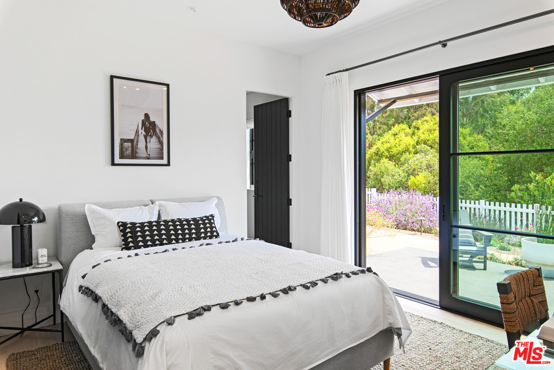 6530 Zuma View Place Malibu, CA 90265 - Photo 14 of 31 a bedroom with a large window and a bed