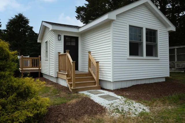 a view of a house with backyard and wooden fence