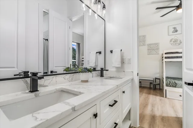 a bathroom with double vanity sinks a mirror and a shower
