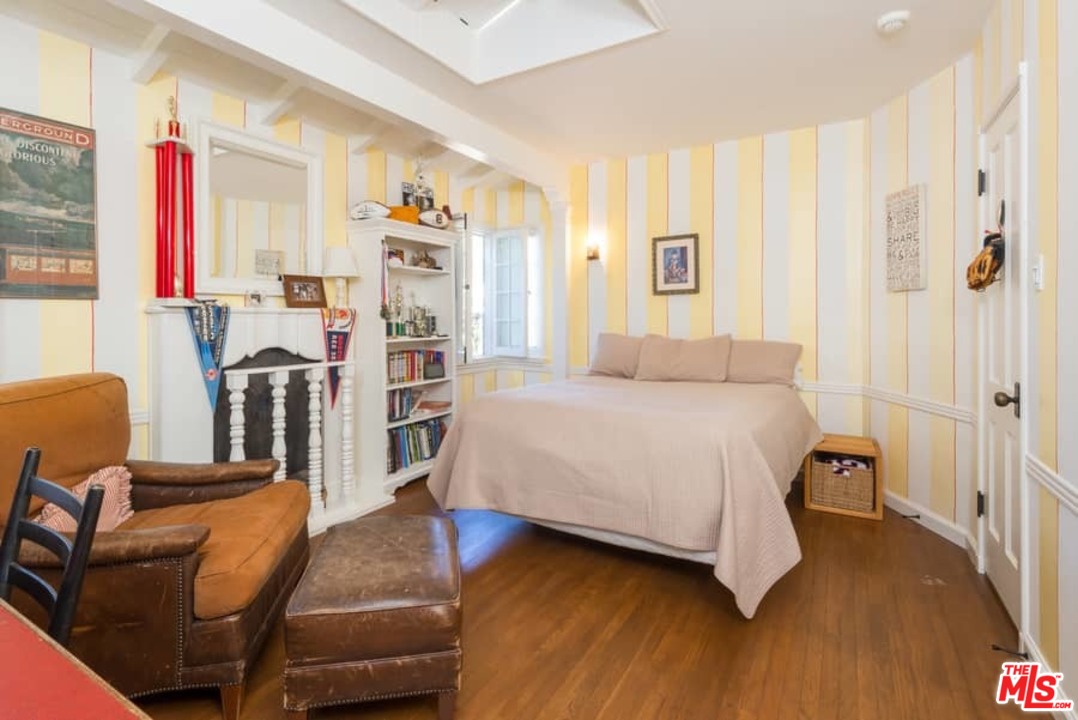 1766 Westridge Road Los Angeles, CA 90049 - Photo 43 of 54 a bedroom with a bed wooden floor and a window
