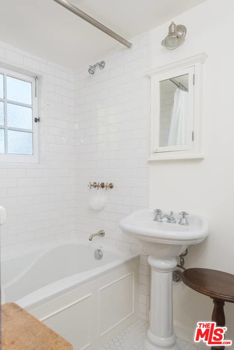1766 Westridge Road Los Angeles, CA 90049 - Photo 48 of 54 a bathroom with a sink a mirror and a bathtub