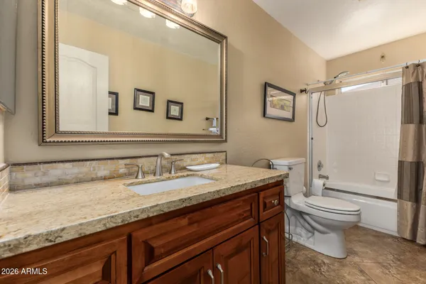 a bathroom with a granite countertop sink toilet and shower