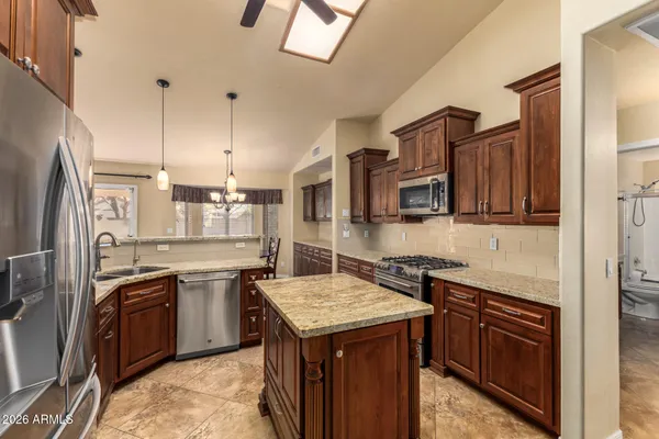 a kitchen with stainless steel appliances granite countertop a sink a stove and a refrigerator