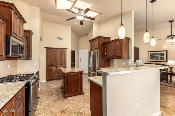 a kitchen with a sink a stove and chairs