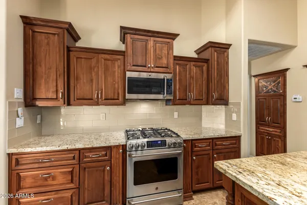 a kitchen with granite countertop a stove and a sink