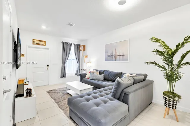 a living room with furniture and a potted plant