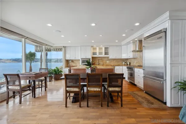a kitchen with a dining table chairs appliances and cabinets