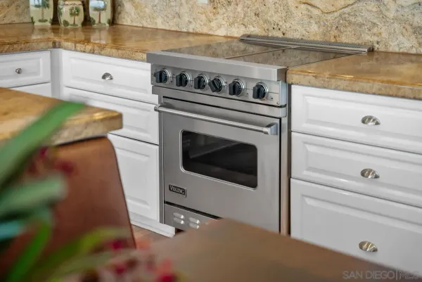 a kitchen with stainless steel appliances granite countertop a sink stove and cabinets